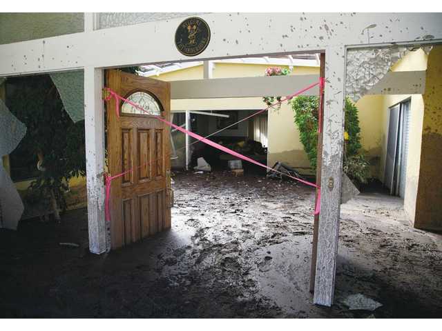 Evacuees begin to return to mud-ridden homes