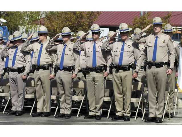 The California Highway Patrol memorial drill team performs a 21gun salute 