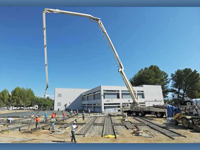 Workers pour concrete as part of COC library expansion