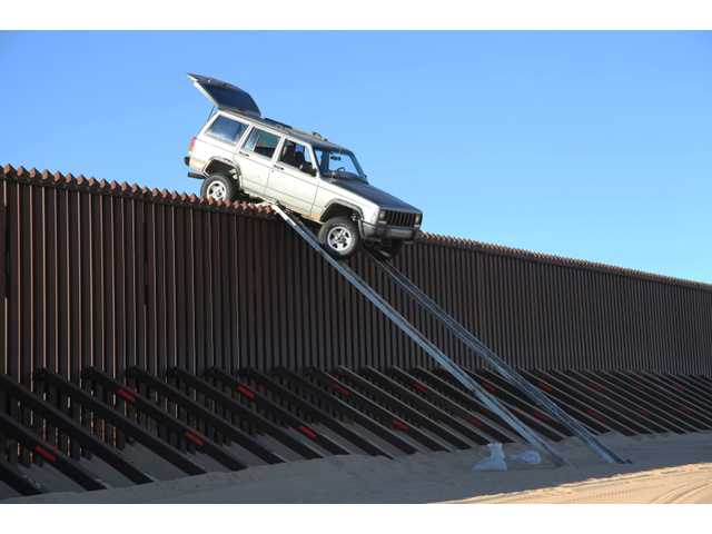 Smugglers' SUV gets stuck atop Calif. border fence 