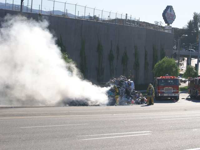 UPDATE: Flaming trash dumped next to highway