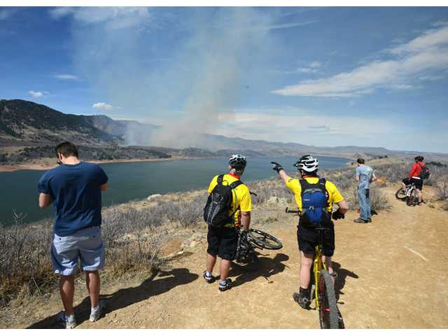 Colo. fire burns in erratic winds, threatens homes 